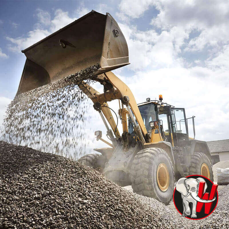 Radlader beim Aufnehmen und Umsetzen von Schotter auf dem Baustofflager.